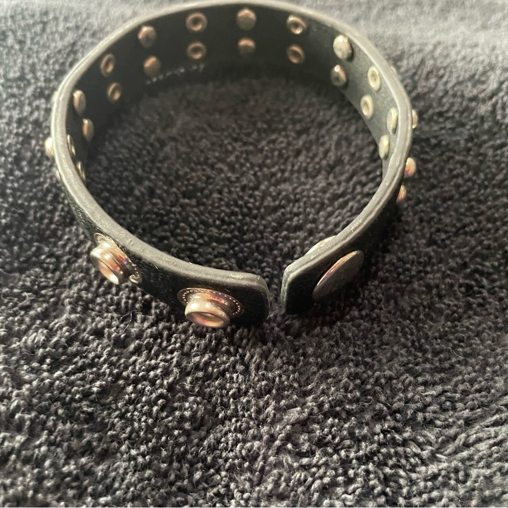 Black leather band with alternating rows if 2 silver studs or 2 “diamonds”